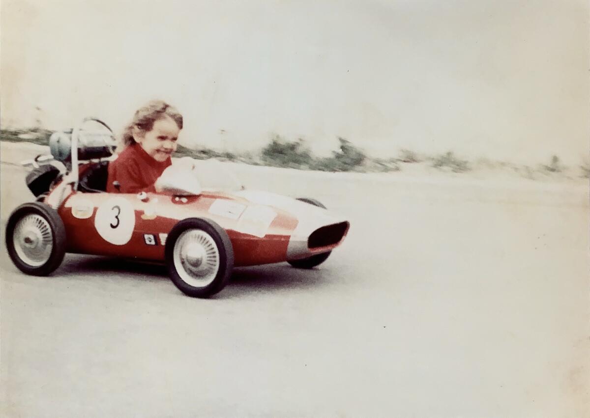 Bild vergrößern: Das Bild zeigt ein Kind in einem roten Kinderauto.