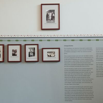 Bild vergrößern: Ausstellungswand im Klassenzimmer mit Fotos der einstigen Lehrer.